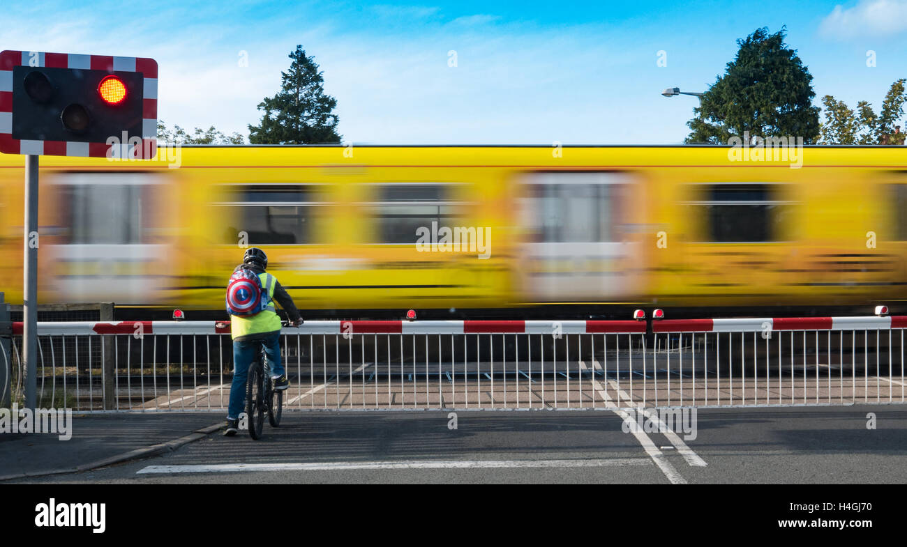 Il treno attraversa chiuso passaggio a livello. Foto Stock