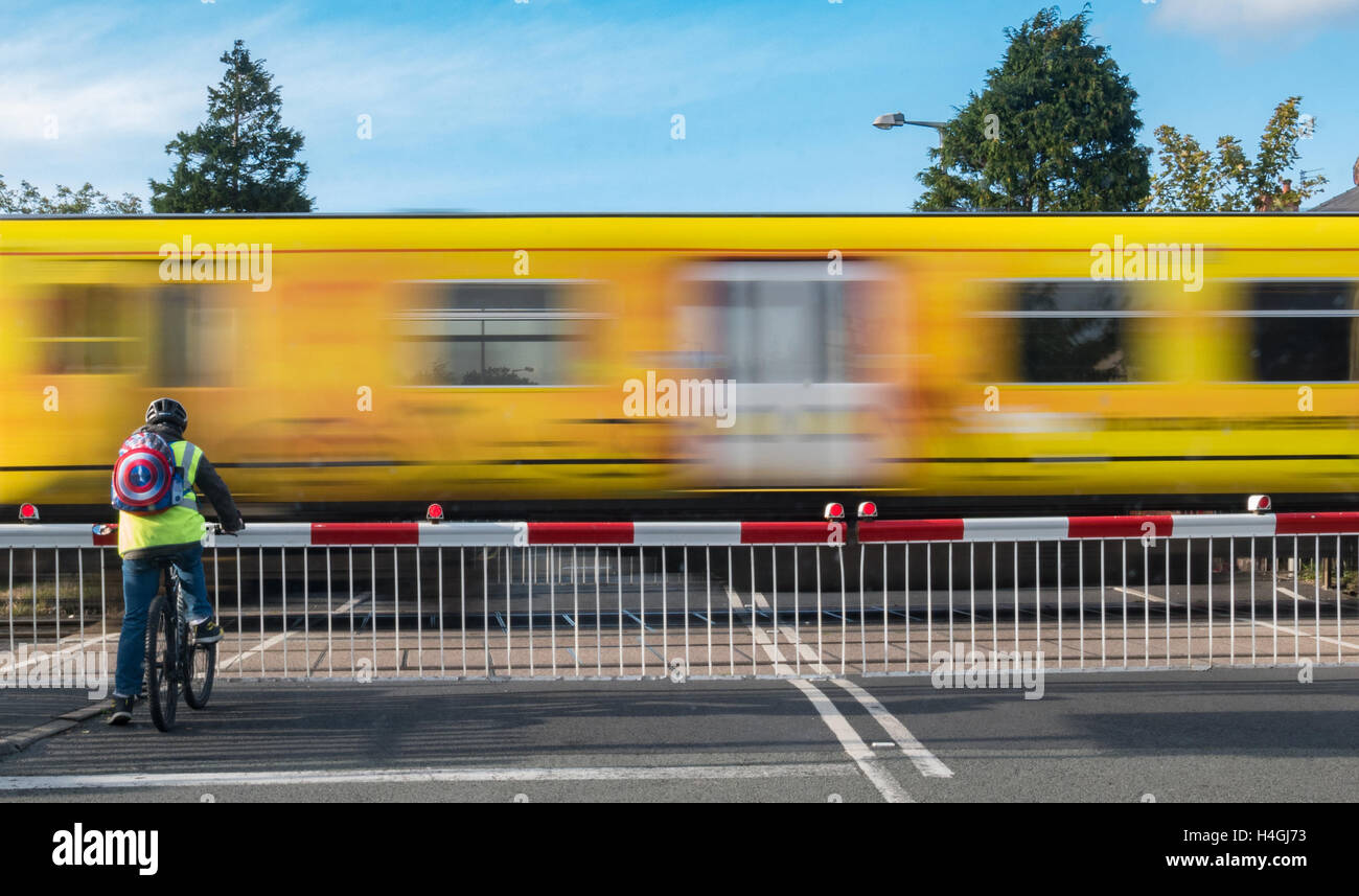 Il treno attraversa chiuso passaggio a livello. Foto Stock