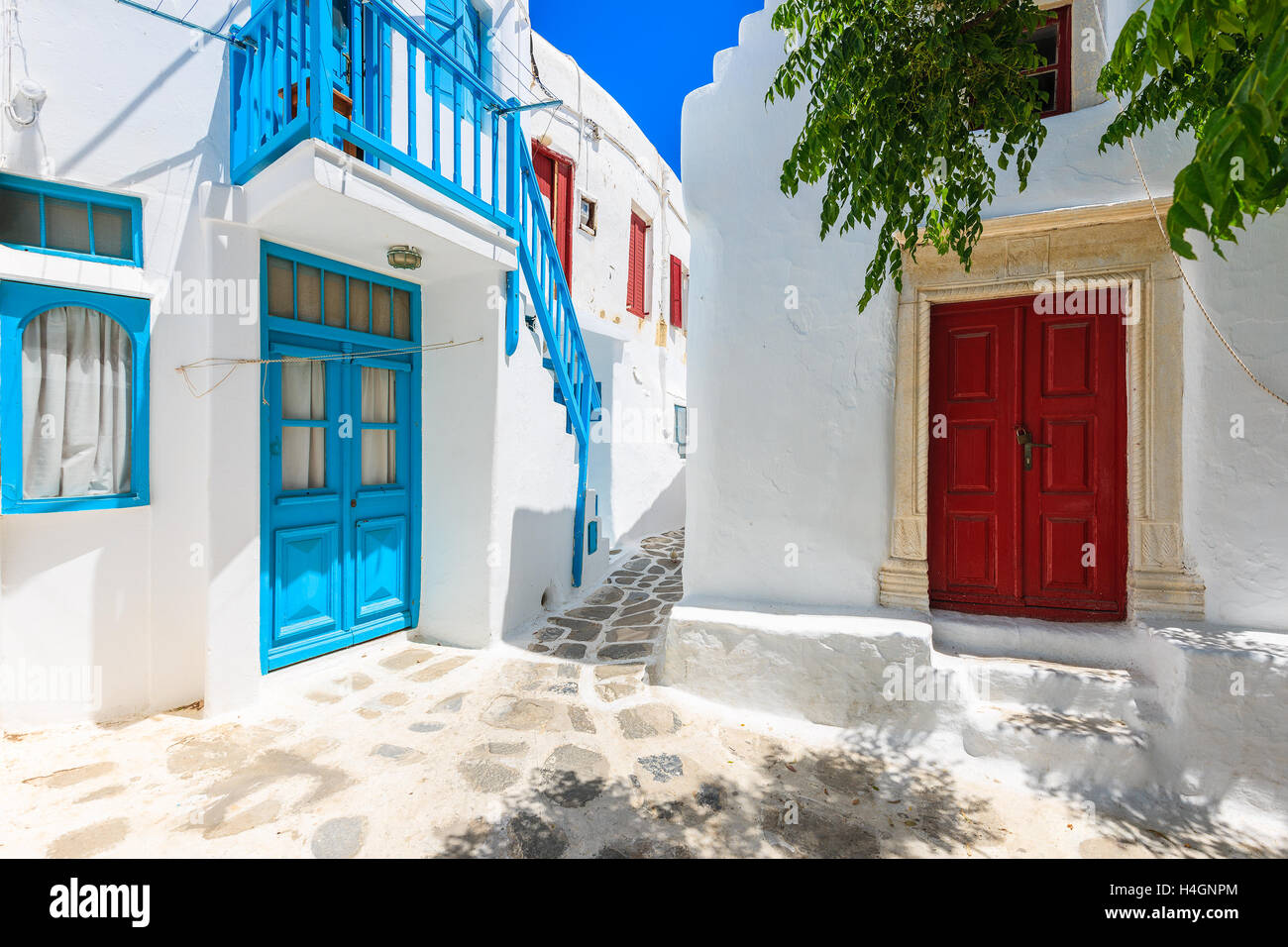 Una vista della strada dipinte di bianco con blu di Windows e le porte nella bellissima città di Mykonos, Cicladi, Grecia Foto Stock