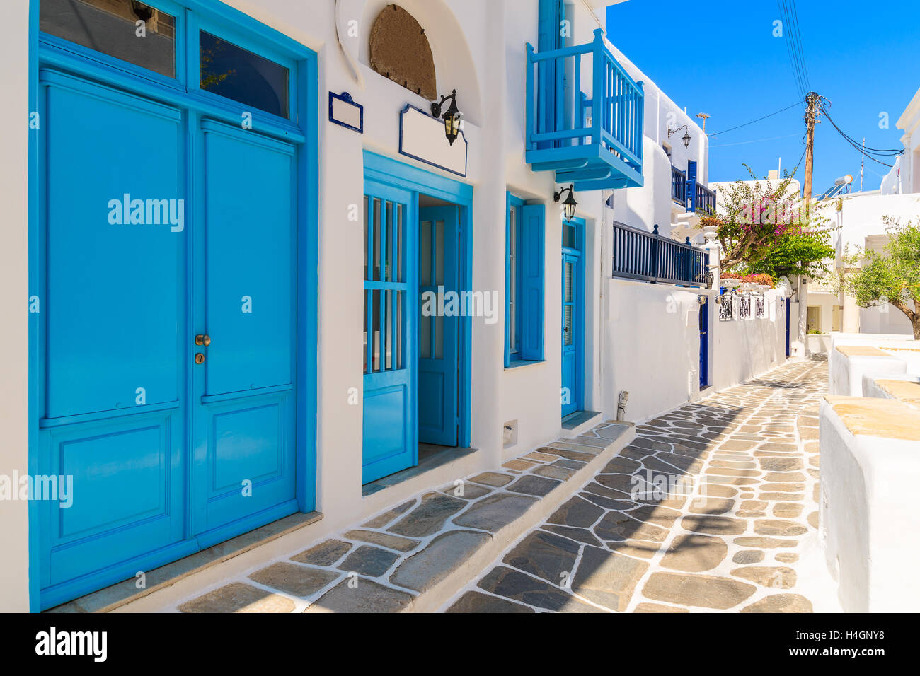 Tipico Greco bianco case con porte e finestre blu sulla strada della bella città di Mykonos, Cicladi, Grecia Foto Stock
