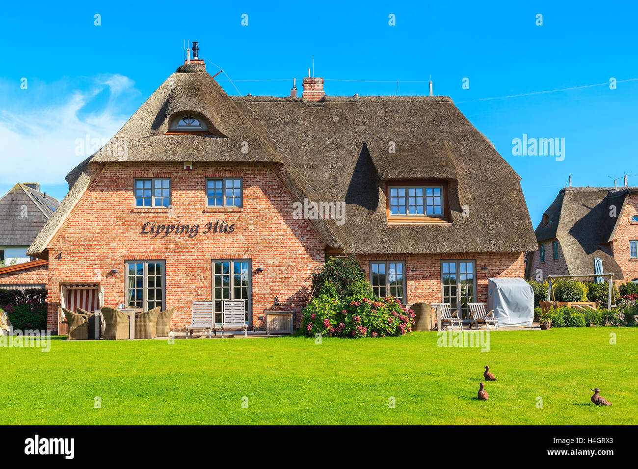 Isola di Sylt, Germania - Sep 11, 2016: casa tradizionale con tetto di paglia e verde giardino sulla isola di Sylt in Wenningstedt villag Foto Stock