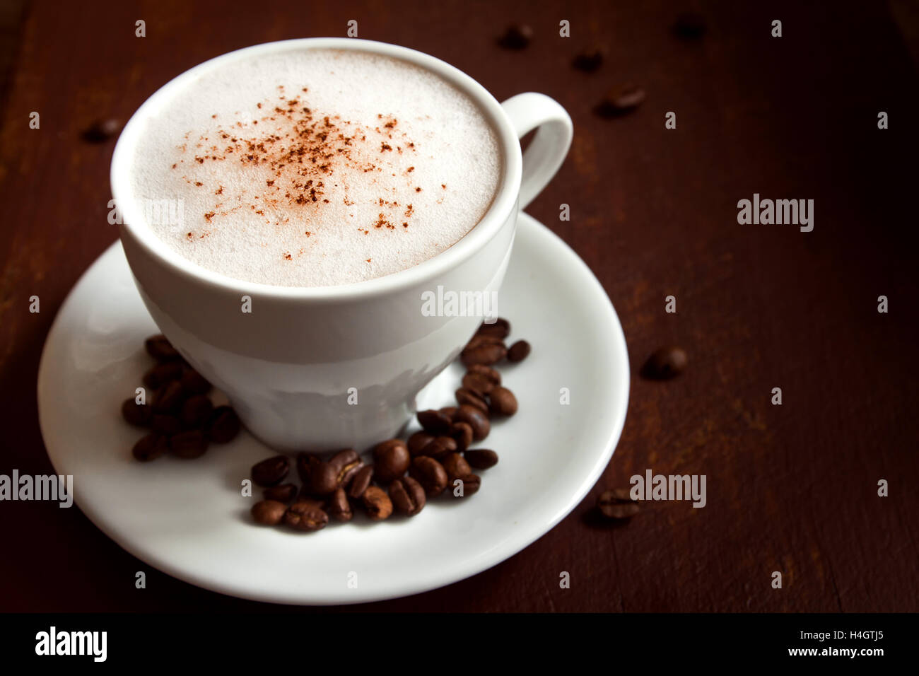 Tazza di caffè cappuccino con cacao topping più scuri in legno rustico sfondo Foto Stock