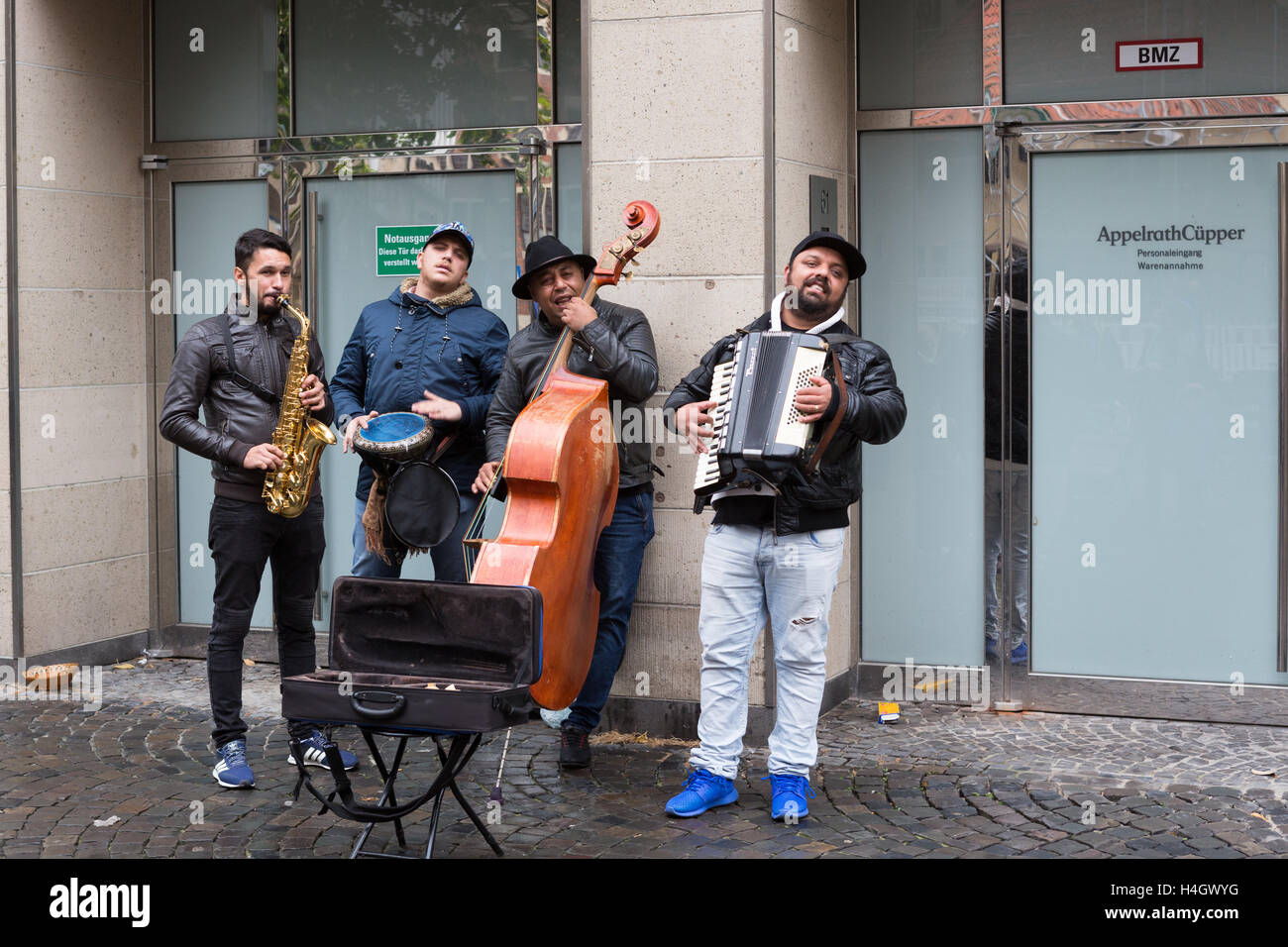 Quattro musicisti maschio del medio oriente apparenza suonare gli strumenti in strada in Germania Foto Stock