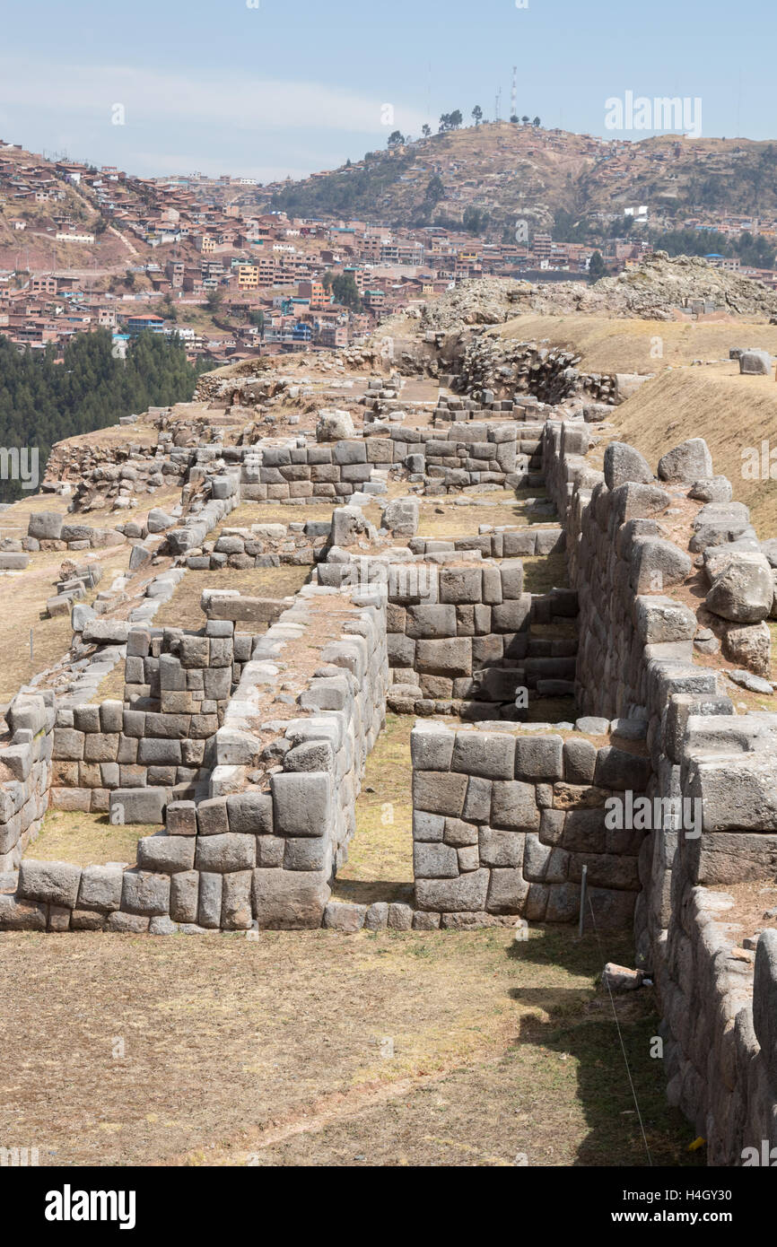 Vista da sopra della pietra Inca rovine a Sacsaywaman, con edifici di Cusco in background Foto Stock