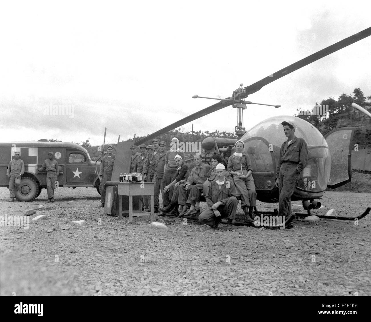 Stati Uniti I medici dell'esercito e dell'equipaggio pongono di fronte a un Bell Helicopter presso la sede dell'8225th esercito Mobile ospedale chirurgico o unità di MASH durante la Guerra di Corea Ottobre 14, 1951 in Corea. Foto Stock