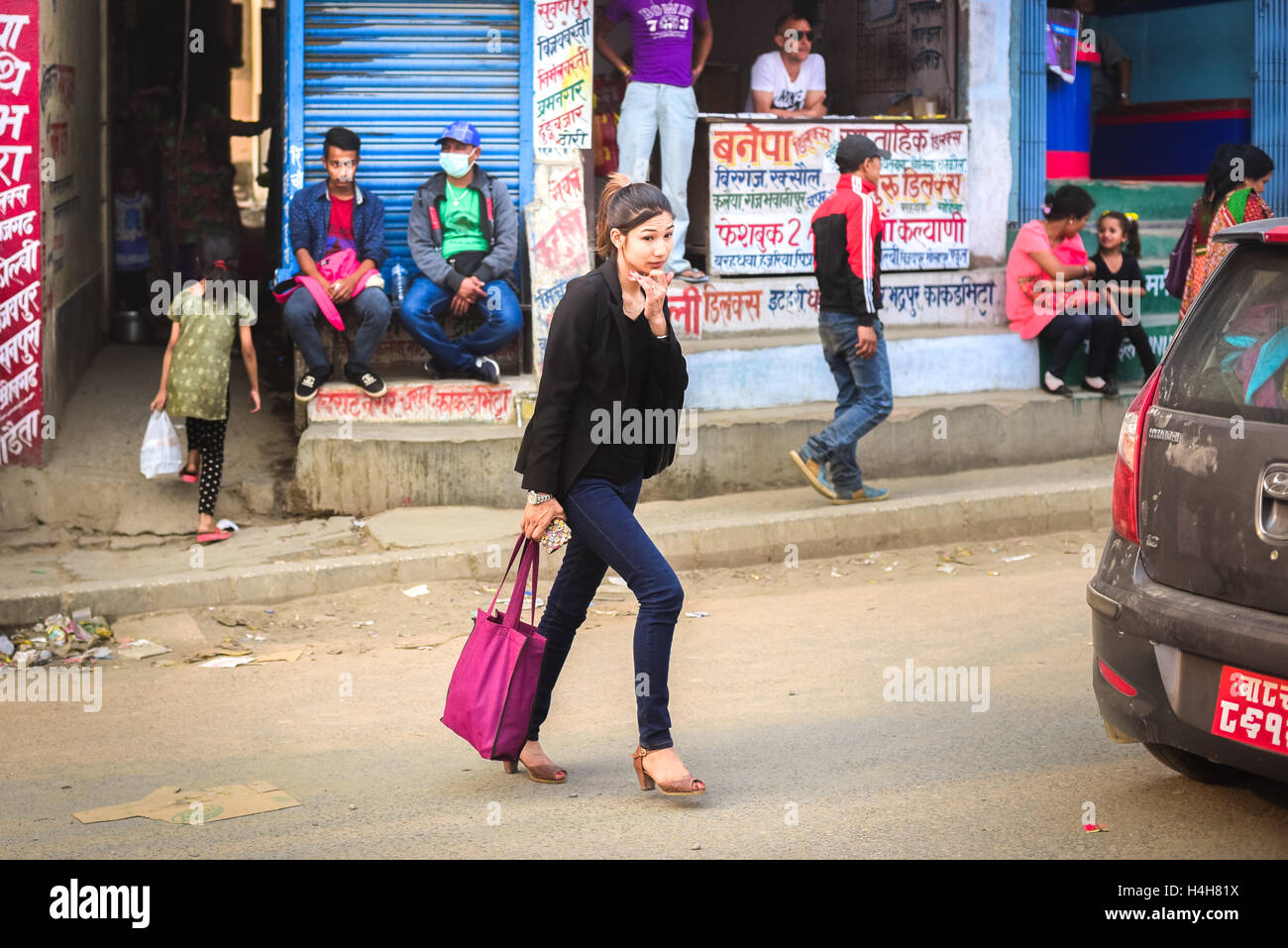 Giovane donna nepalese in moda casual style di attraversare una via nella periferia di Kathmandu, Nepal. Foto Stock