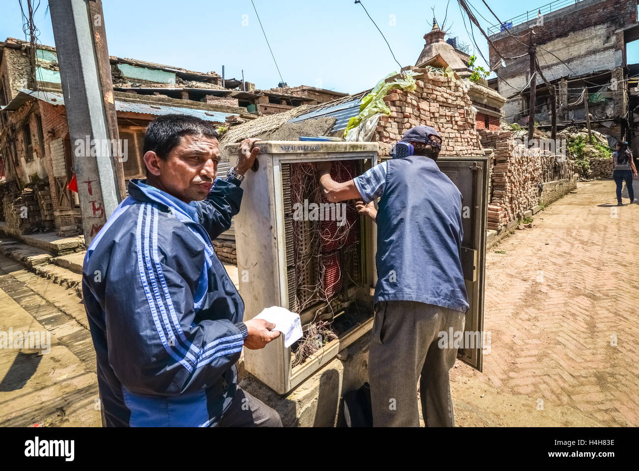 I tecnici stanno effettuando lavori di manutenzione sulla rete telefonica, un anno dopo i terremoti devastanti del 2015 a Bhaktapur, Nepal. Foto Stock