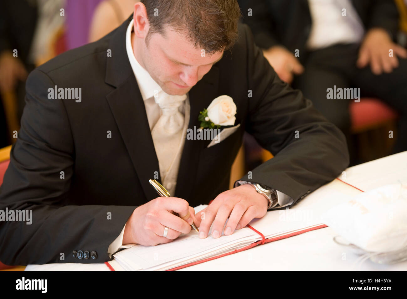 Lo sposo firma il certificato di matrimonio presso l ufficio del registro di sistema Foto Stock