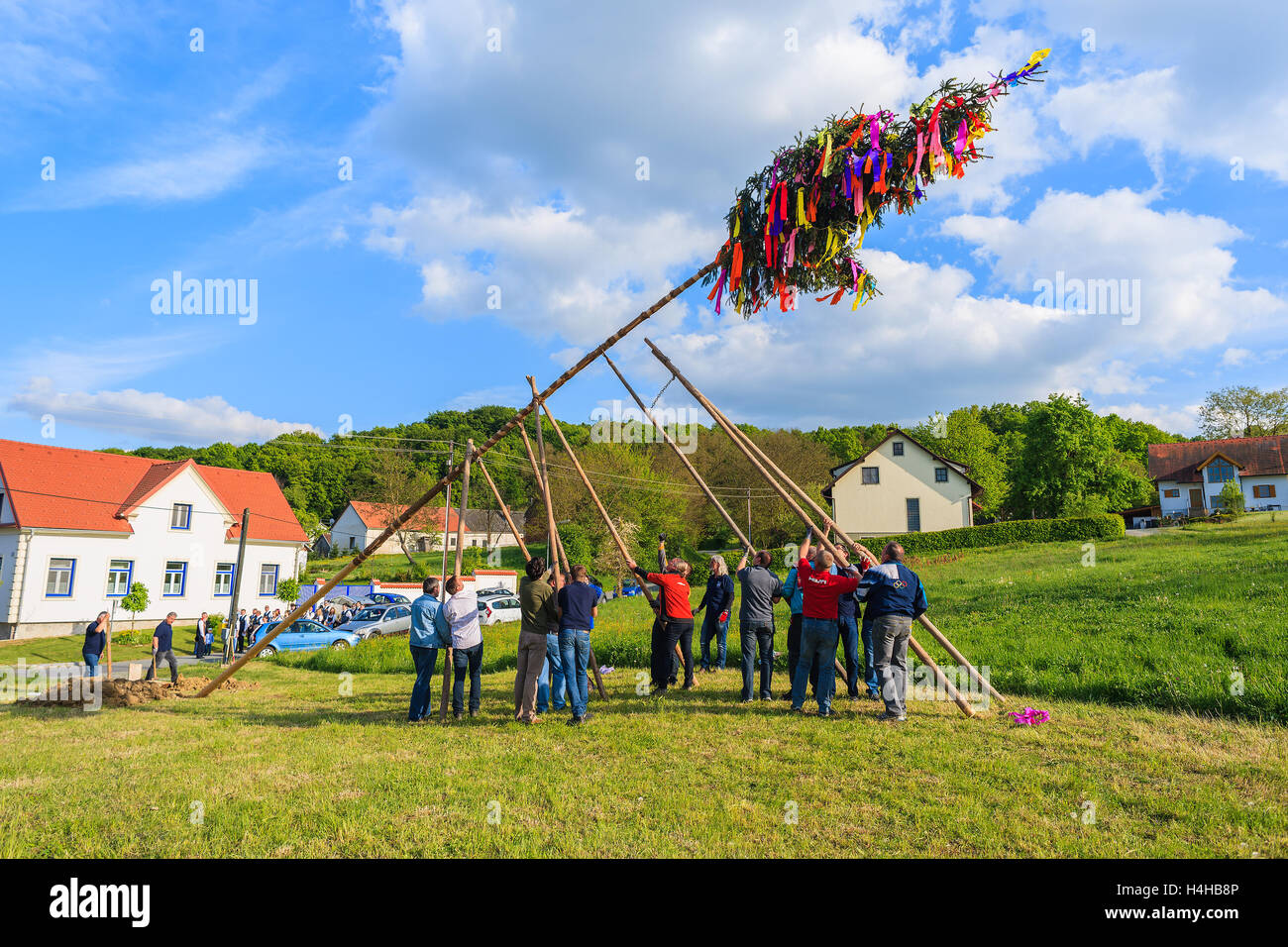 Villaggio GLASING, Austria - Apr 30, 2016: uomini di erigere una struttura può durante la celebrazione della primavera. In Germania e Austria il maypole ho Foto Stock