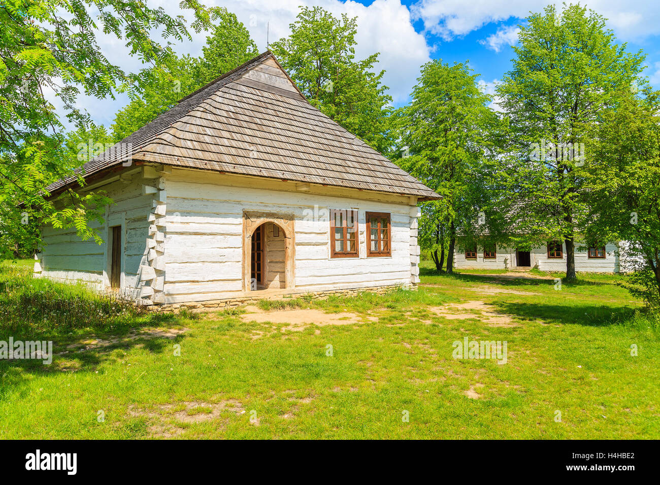 Villaggio TOKARNIA, Polonia - 12 Maggio 2016: un vecchio rustico casa cottage sul prato verde in open air museum nel villaggio Tokarnia, Pol Foto Stock