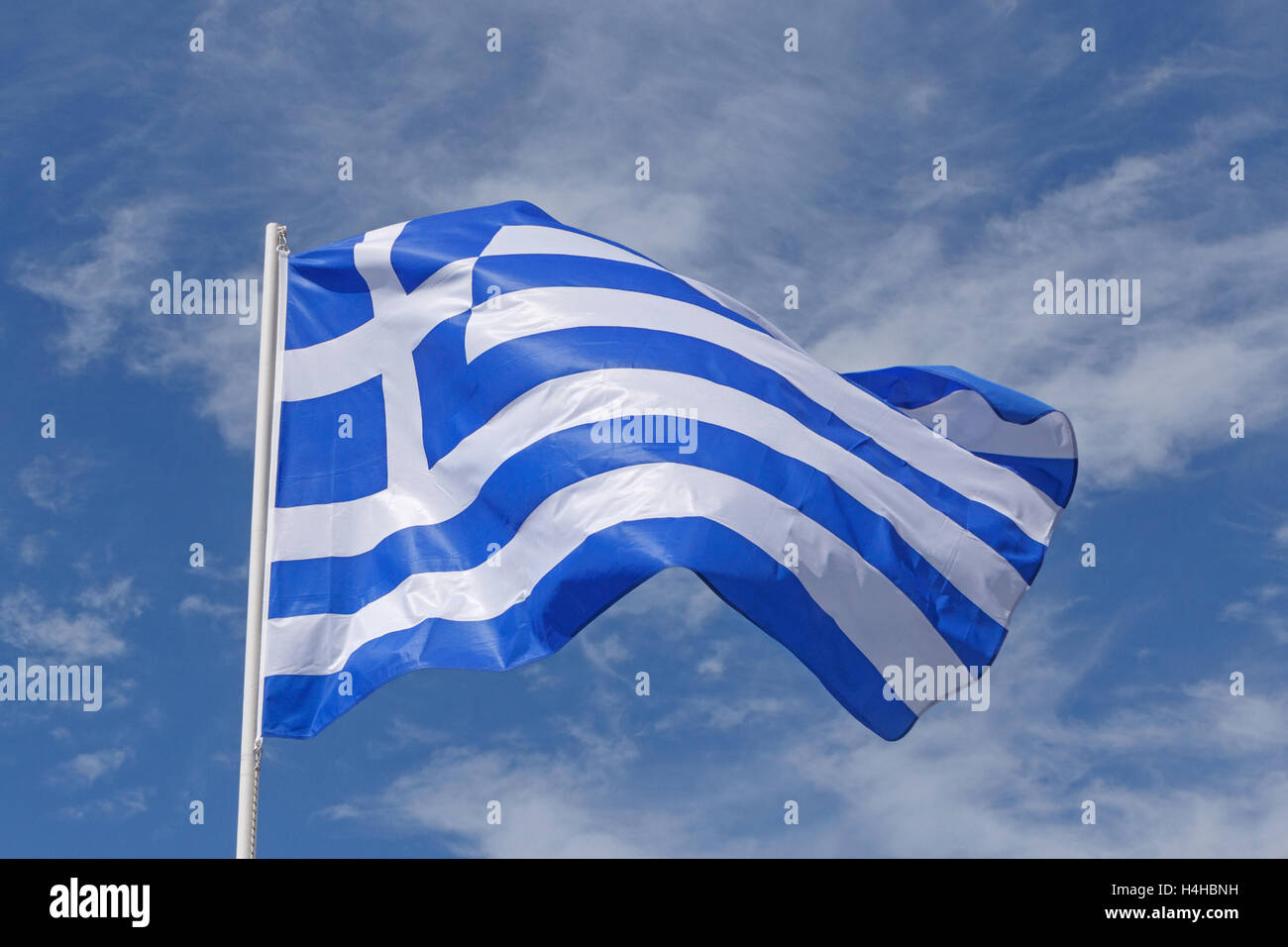Bandiera della Grecia contro il cielo blu con nuvole bianche Foto Stock