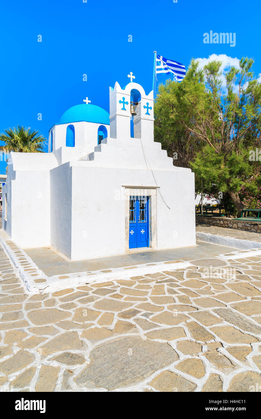 Quadrato con bianca tipica chiesa con cupola blu e la bandiera greca sull isola di Paros, Cicladi Grecia Foto Stock