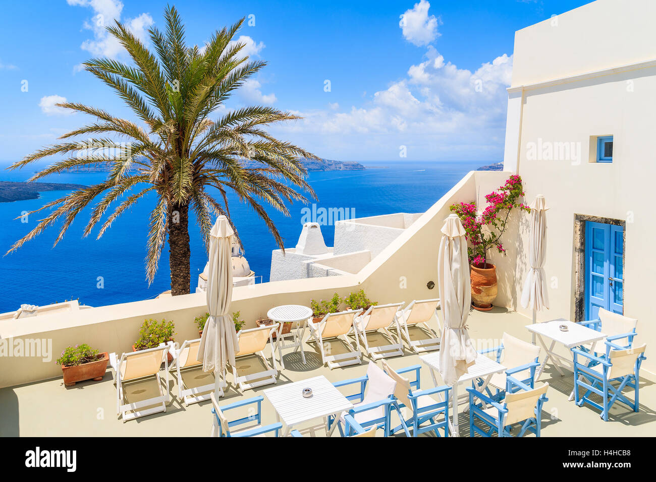 Terrazza con sedie e tavoli in Firostefani villaggio con bianca tipica architettura greca - Santorini Island, Grecia Foto Stock