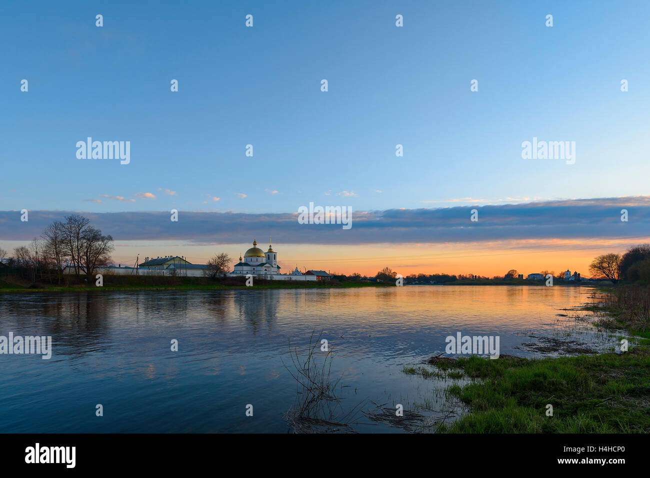 L antico monastero russo sulla riva del fiume al tramonto Foto Stock