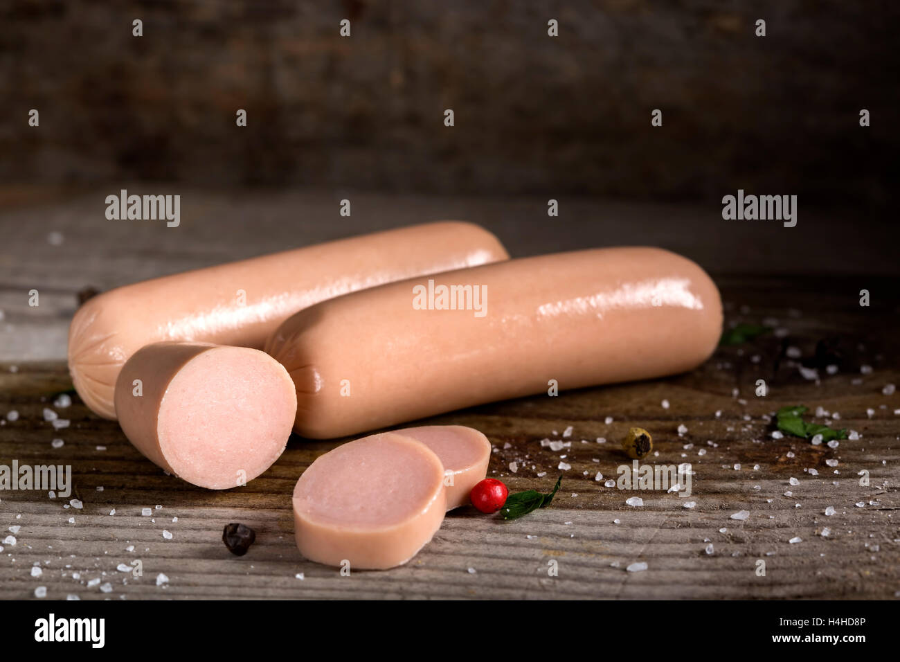 Materie frankfurter salsicce con spezie su sfondo di legno Foto Stock