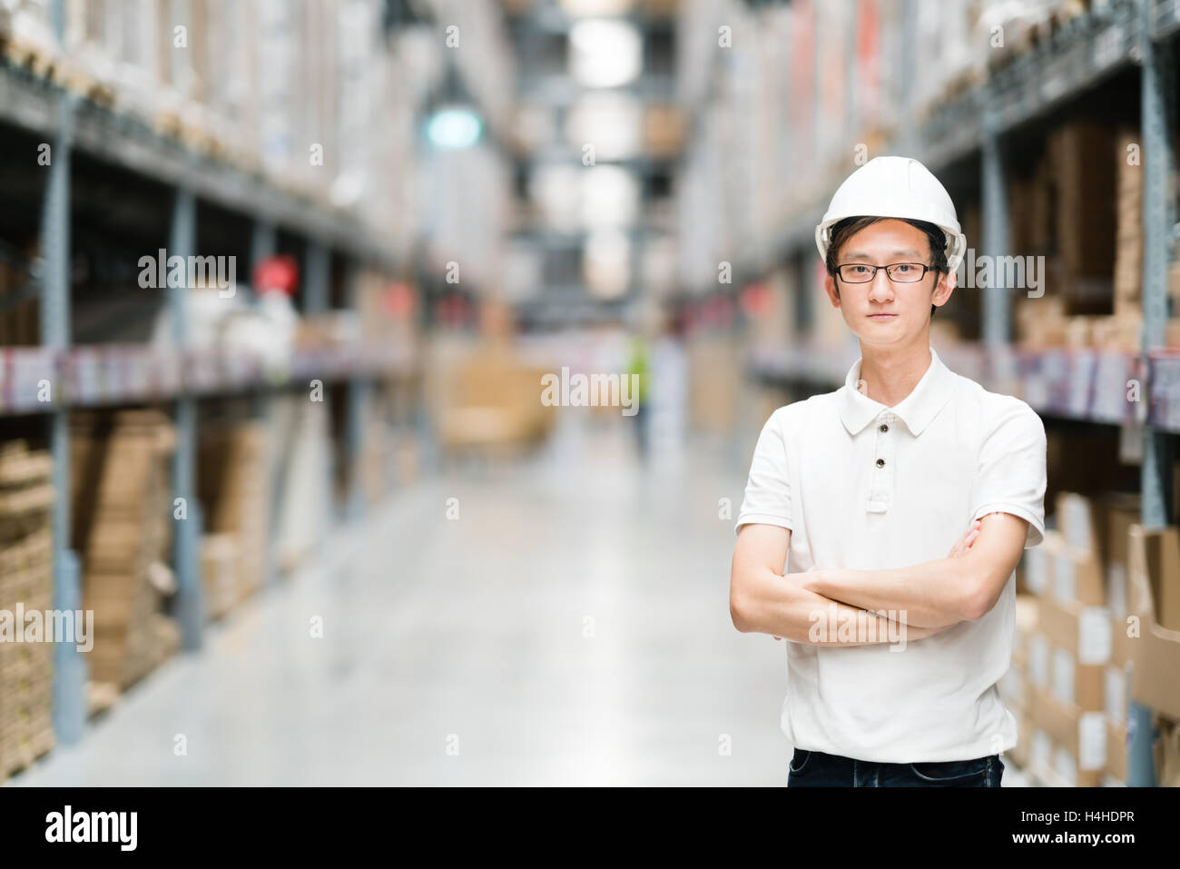 Bel giovane ingegnere asiatici o il tecnico o lavoratore, in magazzino o in fabbrica blur sullo sfondo, industria o concetto logistico, con Foto Stock