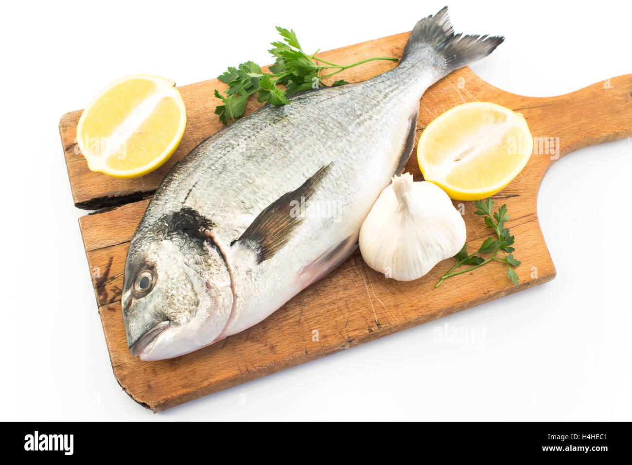 Pesce Dorada con limone, prezzemolo e aglio. Foto Stock