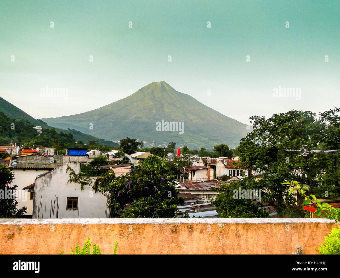 Vulcano Agua al tramonto dal tetto di una casa in Antiqua, Guatemala. Foto Stock