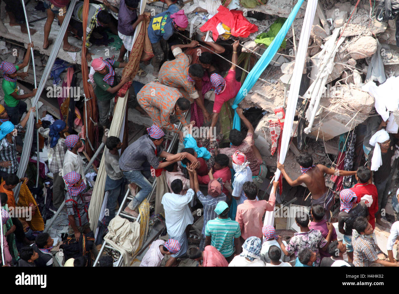 Popolo del Bangladesh si riuniscono come soccorritori look per i superstiti e vittime in corrispondenza del sito di Rana Plaza edificio è crollato in Savar, Foto Stock