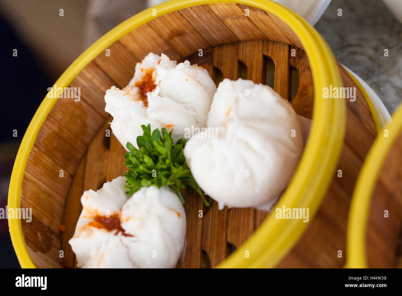 Vaporizzato Chinese bun o saipao rosso ripiene di carne di maiale stagionatura decorate nizza nel sistema di cottura a vapore locale di bambù Foto Stock