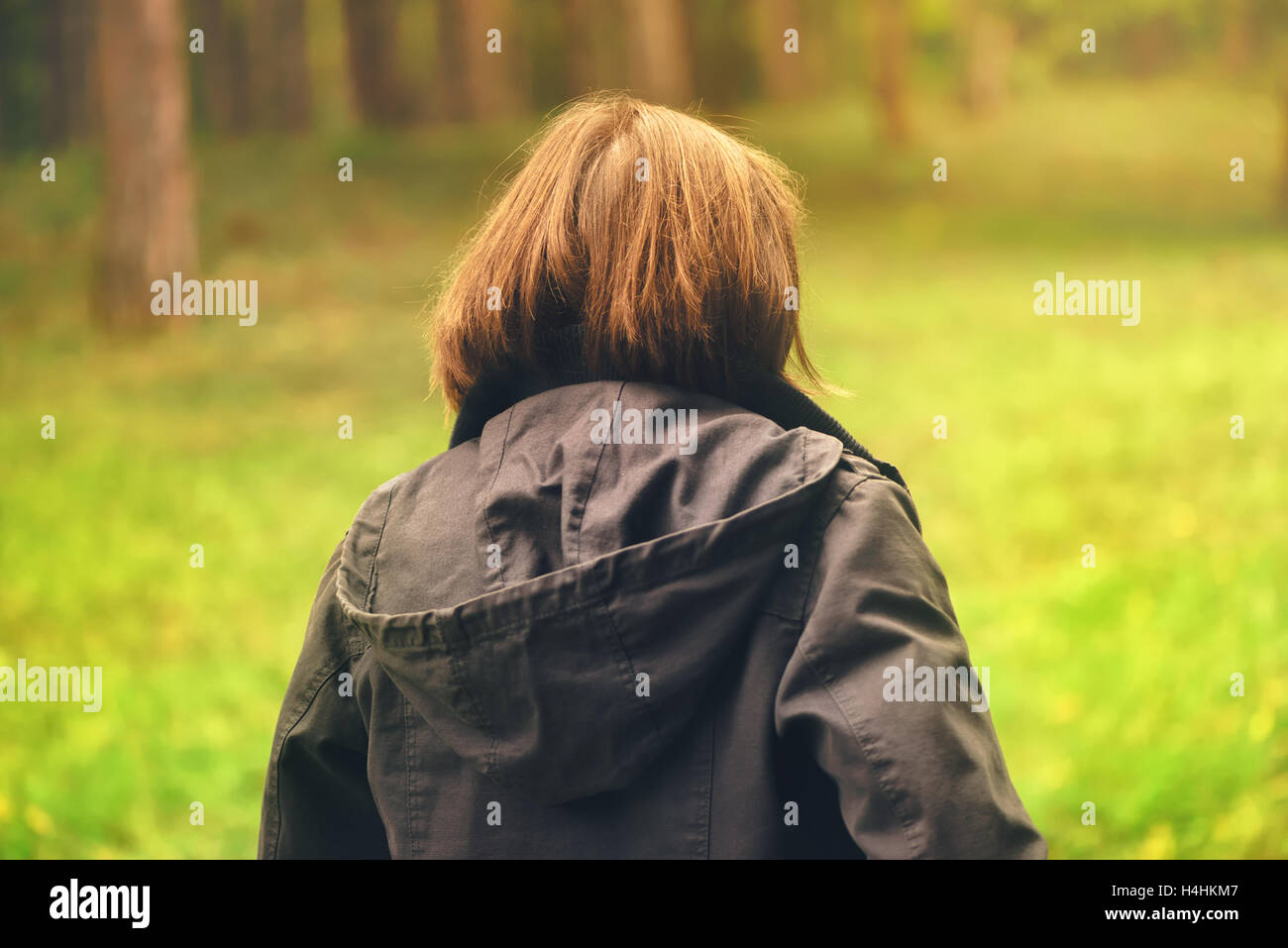 Vista posteriore del casual donna camminando in autunno o parco foresta, donna in caduta stagione ambiente scenario da dietro Foto Stock