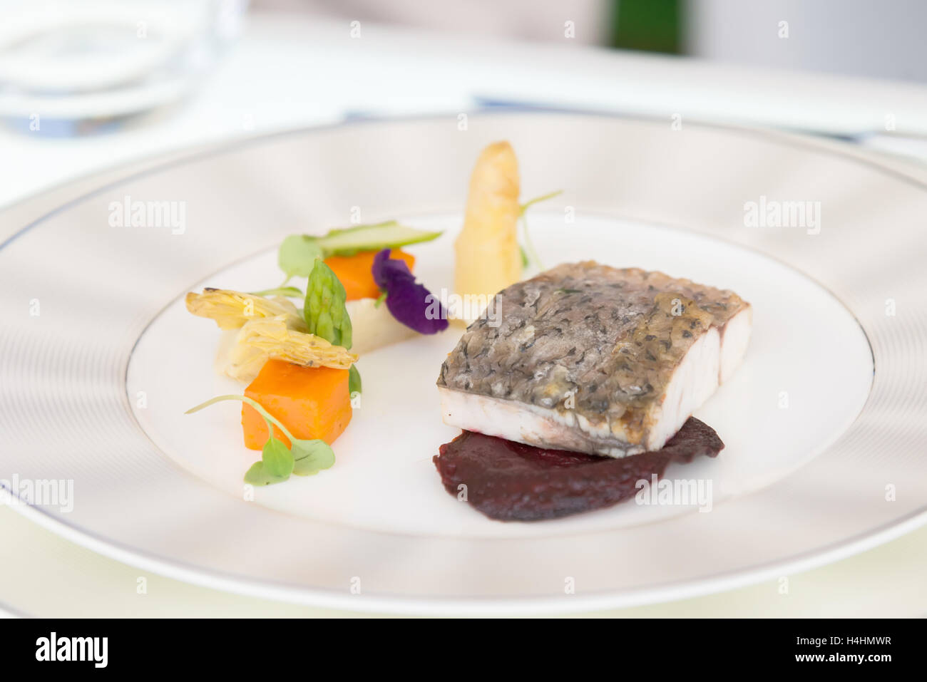 La minimalistica piatto di pesce con verdure sulla piastra bianca Foto Stock