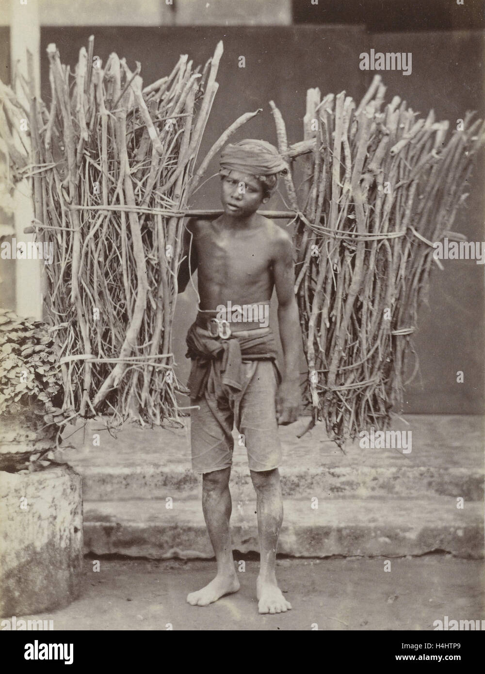 Ritratto di un Java, Indonesianese uomo con legno raccolta, Indonesia, anonimo, 1880 - 1910 Foto Stock