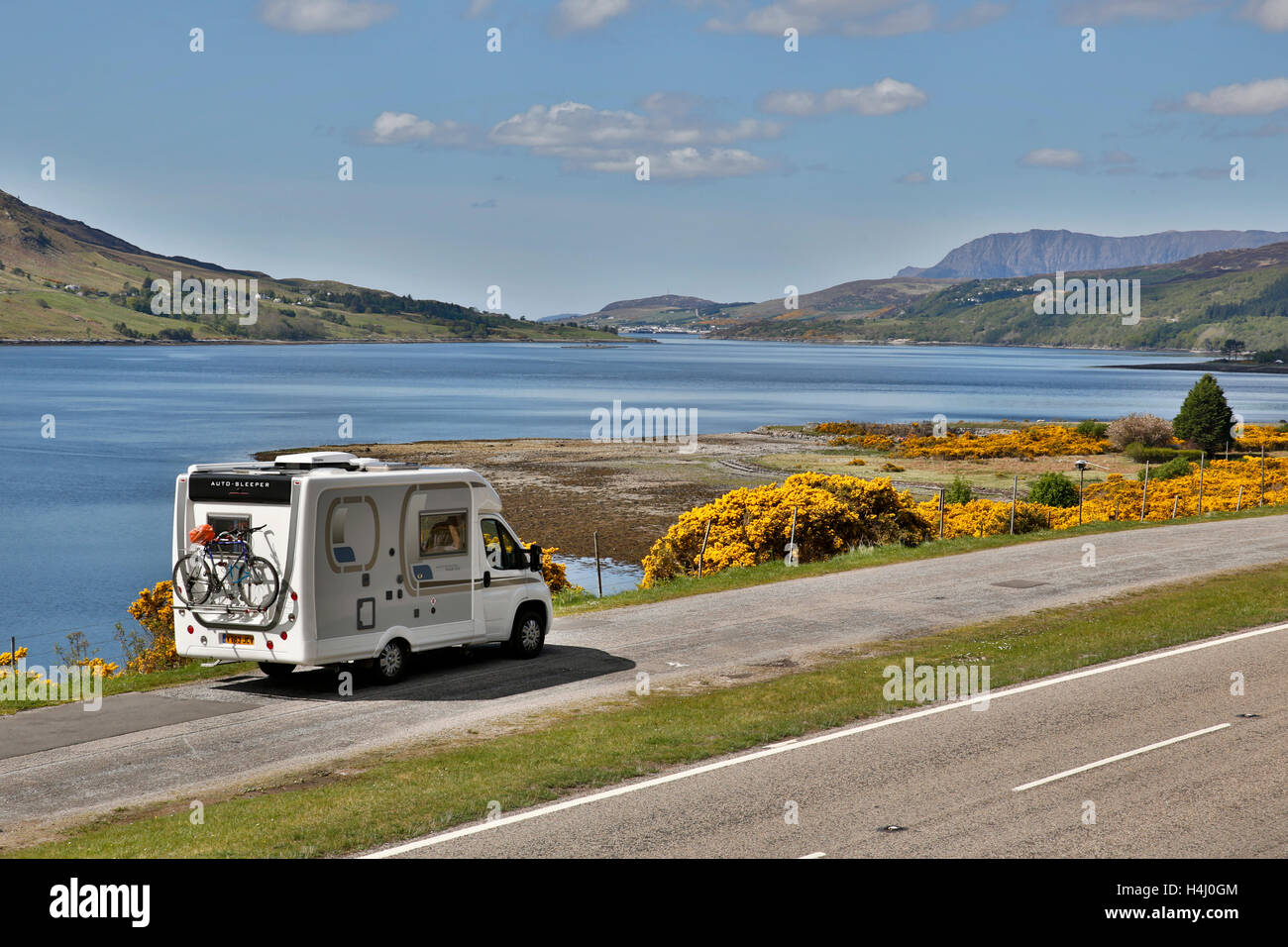 Loch ginestra; Lookig verso Ullapool; camper parcheggiato; ginestre in fiore; Scozia - UK Foto Stock