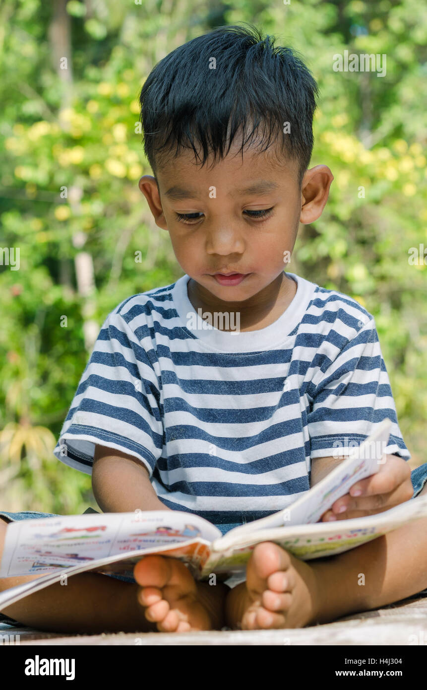 Bambino asiatico concentrare per leggere un libro. Foto Stock