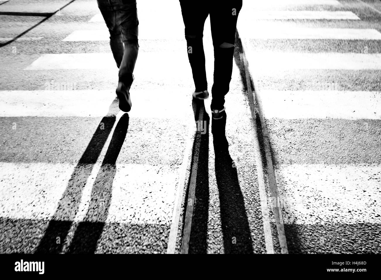 Gambe di due persone e lunga ombra Foto Stock