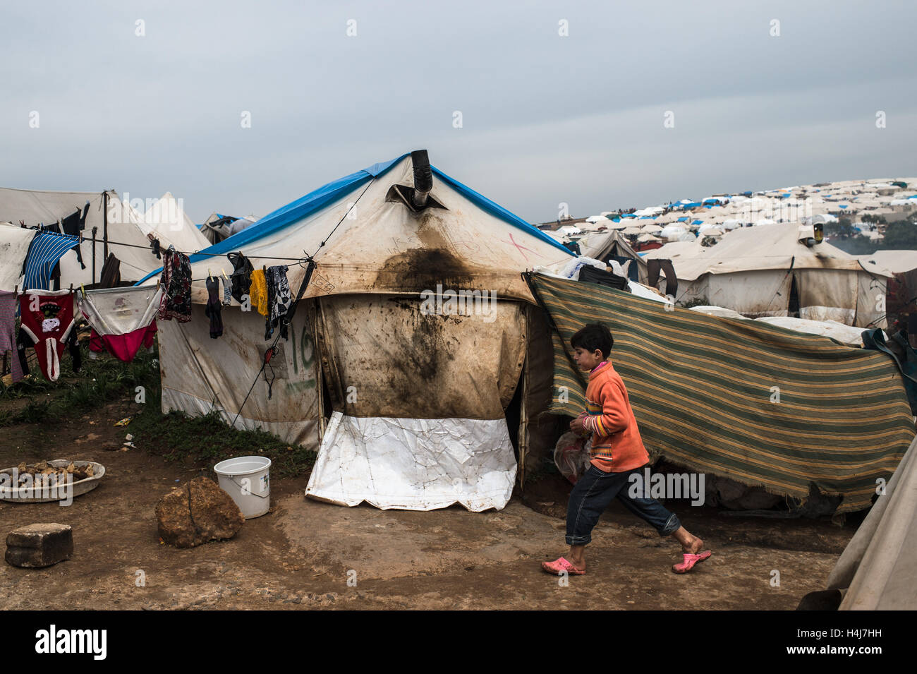 Azaz Refugee Camp vita quotidiana - 22/02/2013 - Siria / Aleppo / Azaz - un giovane rifugiato di Azaz camp, a nord della Siria, corre tra le tende. Il Azaz Refugee Camp accoglie famiglie cercando di sfuggire le contese tra il siriano esercito governativo e il libero esercito siriano. Secondo la ONG "Medical Relief per la Siria', circa 10.000 persone vivono nei campi in preoccupanti condizioni sanitarie. - Edouard Elias / le Pictorium Foto Stock