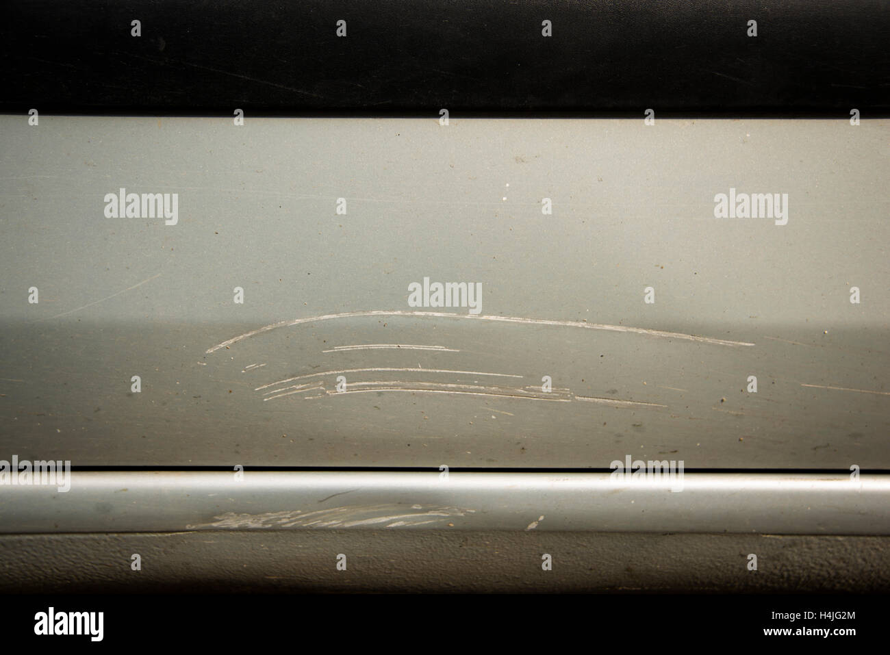 Graffi profondi nel dipinto di grigio di un'auto. Le differenze possono essere visti in parti in plastica e metallo. Foto Stock