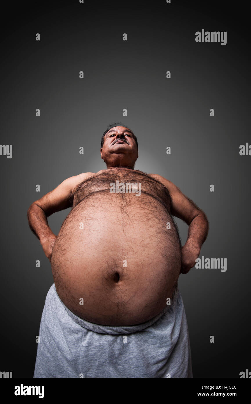 Il forte e uomo grasso che mostra i suoi muscoli e pancia Foto stock - Alamy