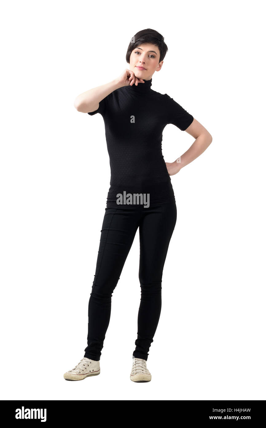 Moda modello femminile in nero dolcevita t-shirt in posa con la mano sul mento. Corpo pieno lunghezza ritratto isolato su bianco Foto Stock