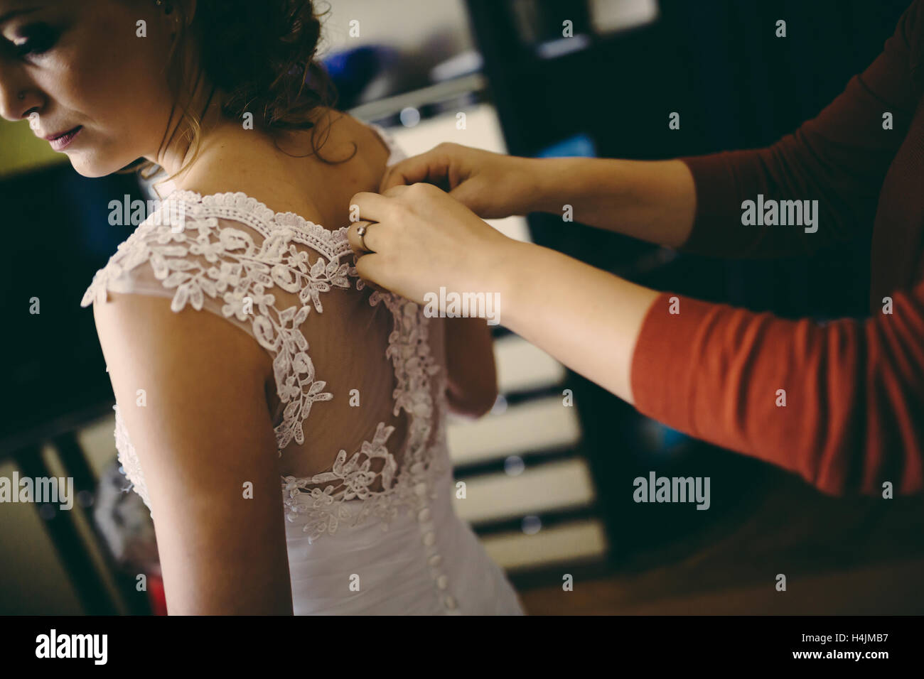 Suor aiutando sposa abito del pulsante Foto Stock