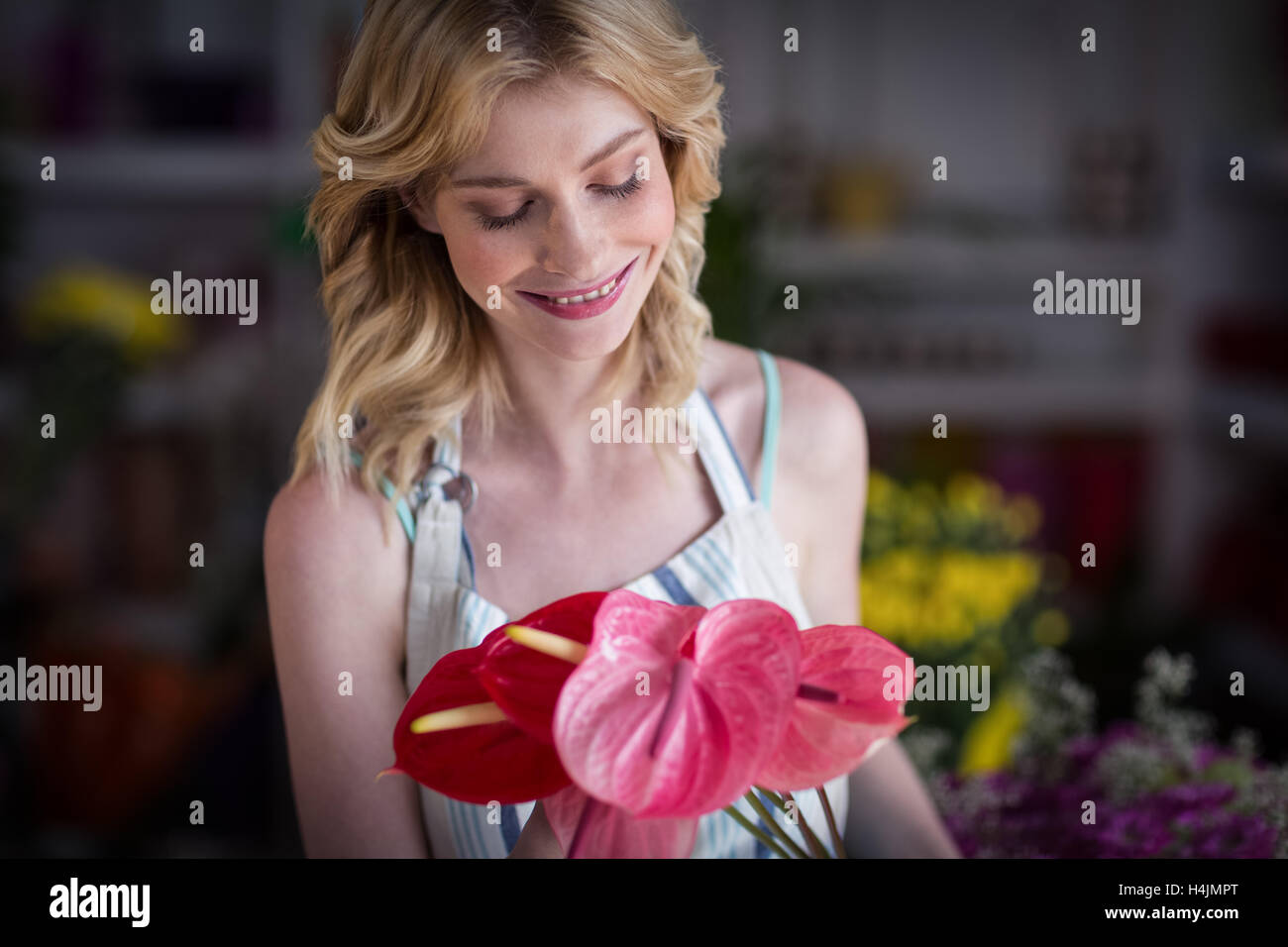 Fiorista femmina holding fiori nel negozio di fiori Foto Stock