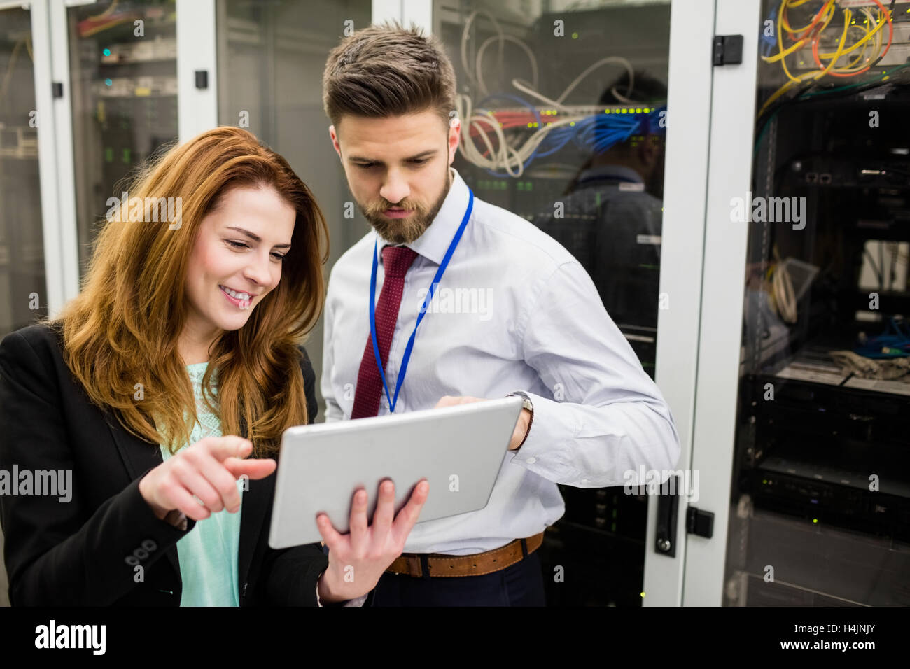 Tecnici che utilizzano digitale compressa durante l'analisi di server Foto Stock