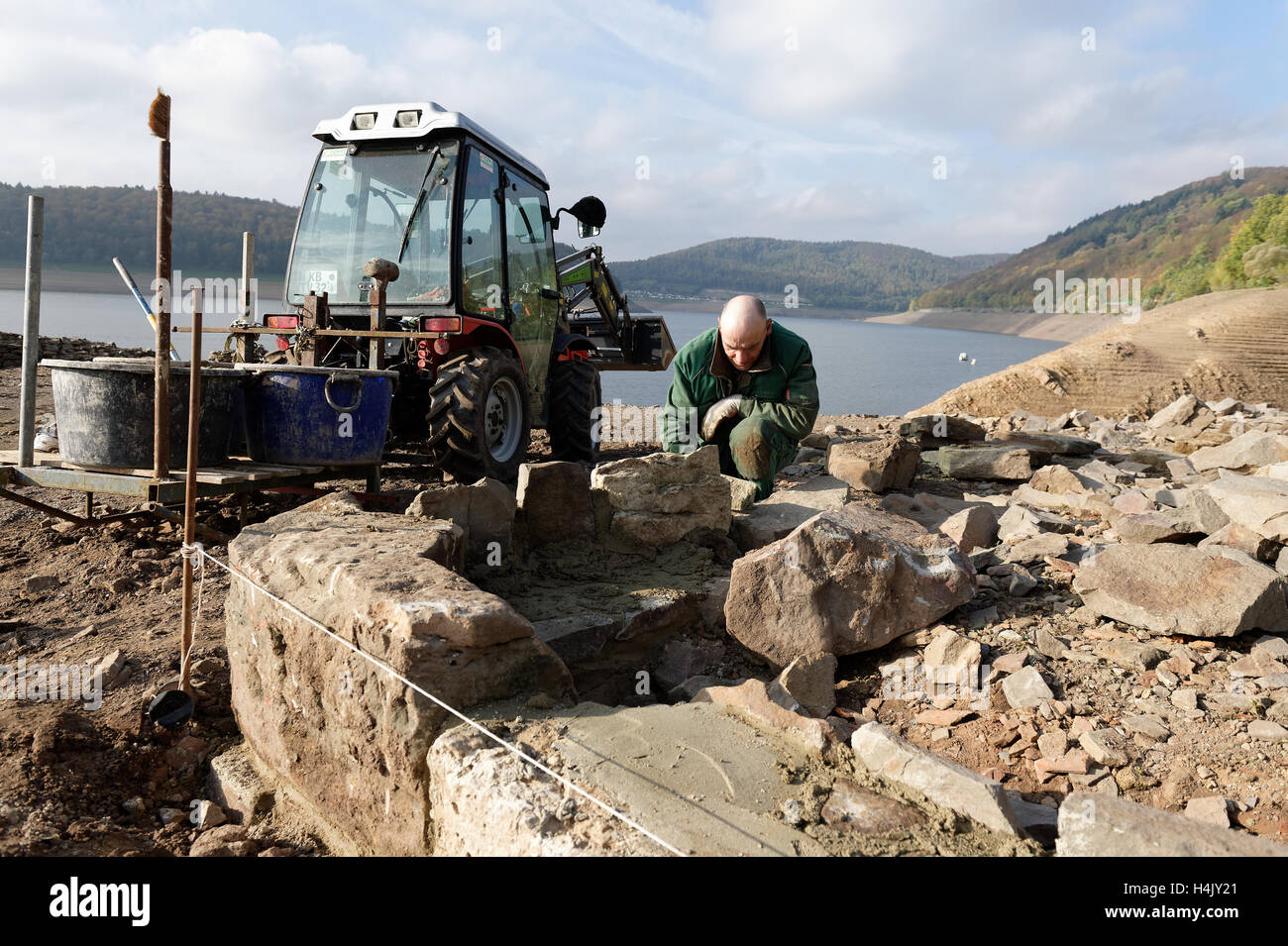 Waldeck, Germania. Xiv oct, 2016. Paesaggio giardiniere Norbert Toffl lavora sui muri di fondazione in zona villaggio Berich che sono sotto l'acqua a più alta marea può essere visto dal lago Edersee vicino a Waldeck, Germania, 14 ottobre 2016. Il villaggio di Berich, che fu la casa di 50 famiglie, è stata rasa al suolo nel 1913 perché una diga doveva essere creato per mantenere il Midland canale navigabile. Gli amici' association Dorfstelle piani Berich sulla ricostruzione i muri di fondazione passo dopo passo. Foto: SWEN PFOERTNER/dpa/Alamy Live News Foto Stock