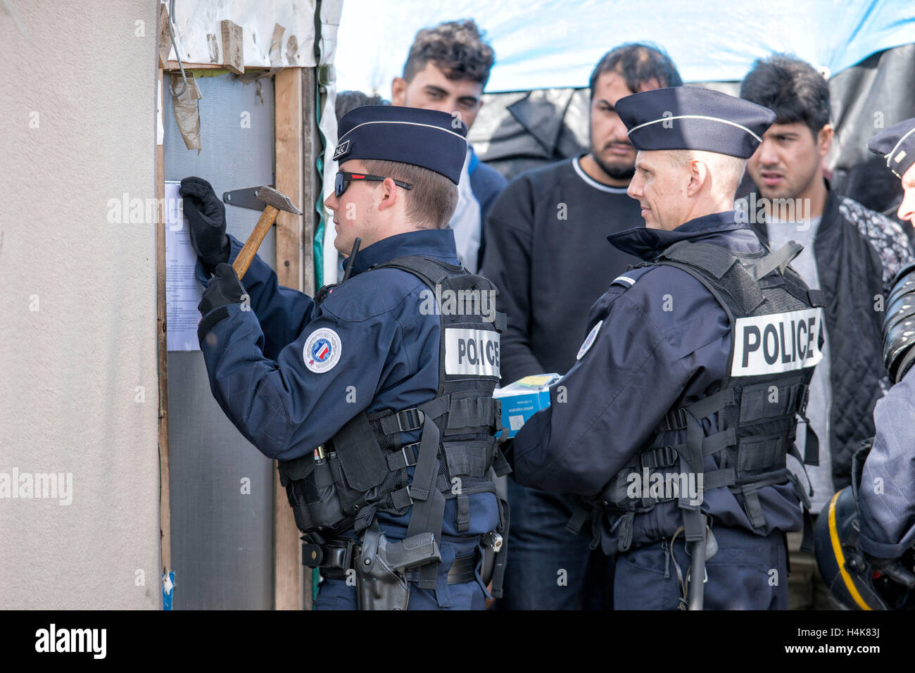 Calais, Francia. Xvii oct, 2016. La gendarmeria francese chiodo un avviso di sfratto per una delle capanne, prima del previsto la demolizione del 'Calais giungla' campo di migranti a Calais, Francia, 17 ottobre 2016. Per anni, i migranti che cercano di entrare clandestinamente nel Regno Unito si sono riuniti nel camp mediante il canale inglese. Foto: ARNULF STOFFEL/DPA/Alamy Live News Foto Stock