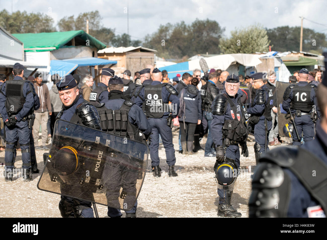 Calais, Francia. Xvii oct, 2016. La gendarmeria francese monitorare la consegna di un avviso di sfratto prima del previsto la demolizione del 'Calais giungla' campo di migranti a Calais, Francia, 17 ottobre 2016. Per anni, i migranti che cercano di entrare clandestinamente nel Regno Unito si sono riuniti nel camp mediante il canale inglese. Foto: ARNULF STOFFEL/DPA/Alamy Live News Foto Stock