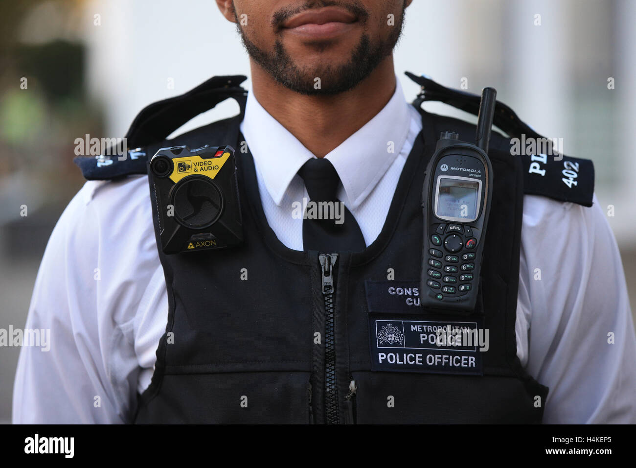 Un poliziotto indossa il nuovo corpo indossato Video (BWV) fotocamera al di fuori di Lewisham a una stazione di polizia di Londra, come distribuzione su vasta scala delle telecamere a oltre 22.000 Metropolitan funzionari di polizia inizia a. Foto Stock