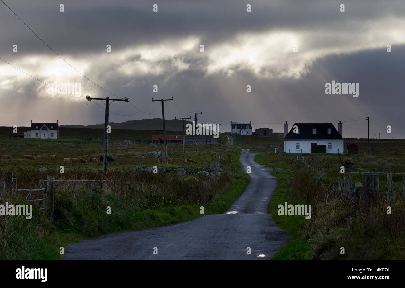 Cielo tempestoso su strada con cottage e paesaggio di Tiree,Ebridi Interne,Argyll and Bute,Scozia Scotland Foto Stock