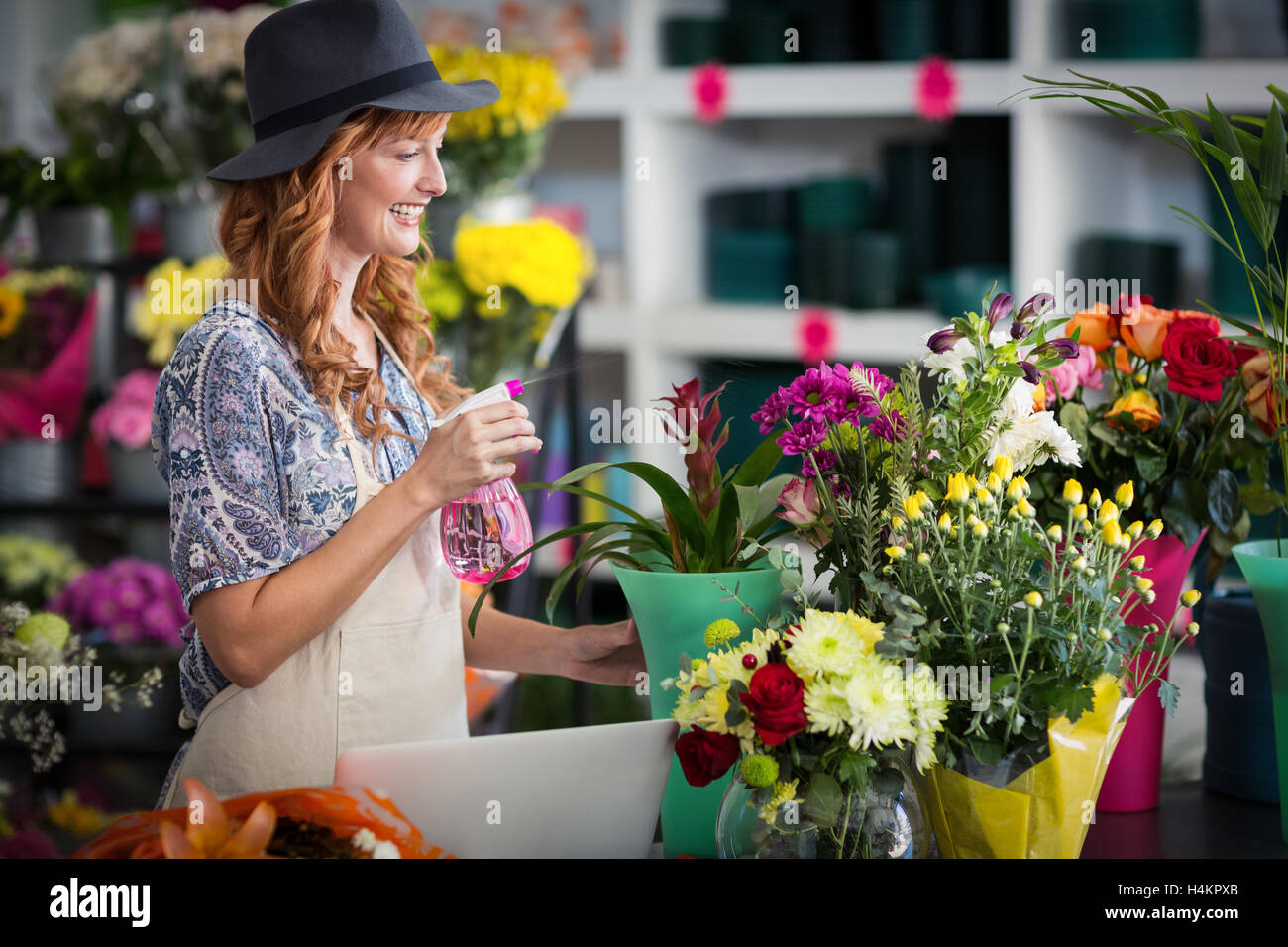 Fioristi spruzzatura di acqua su fiori nel negozio di fiori Foto Stock