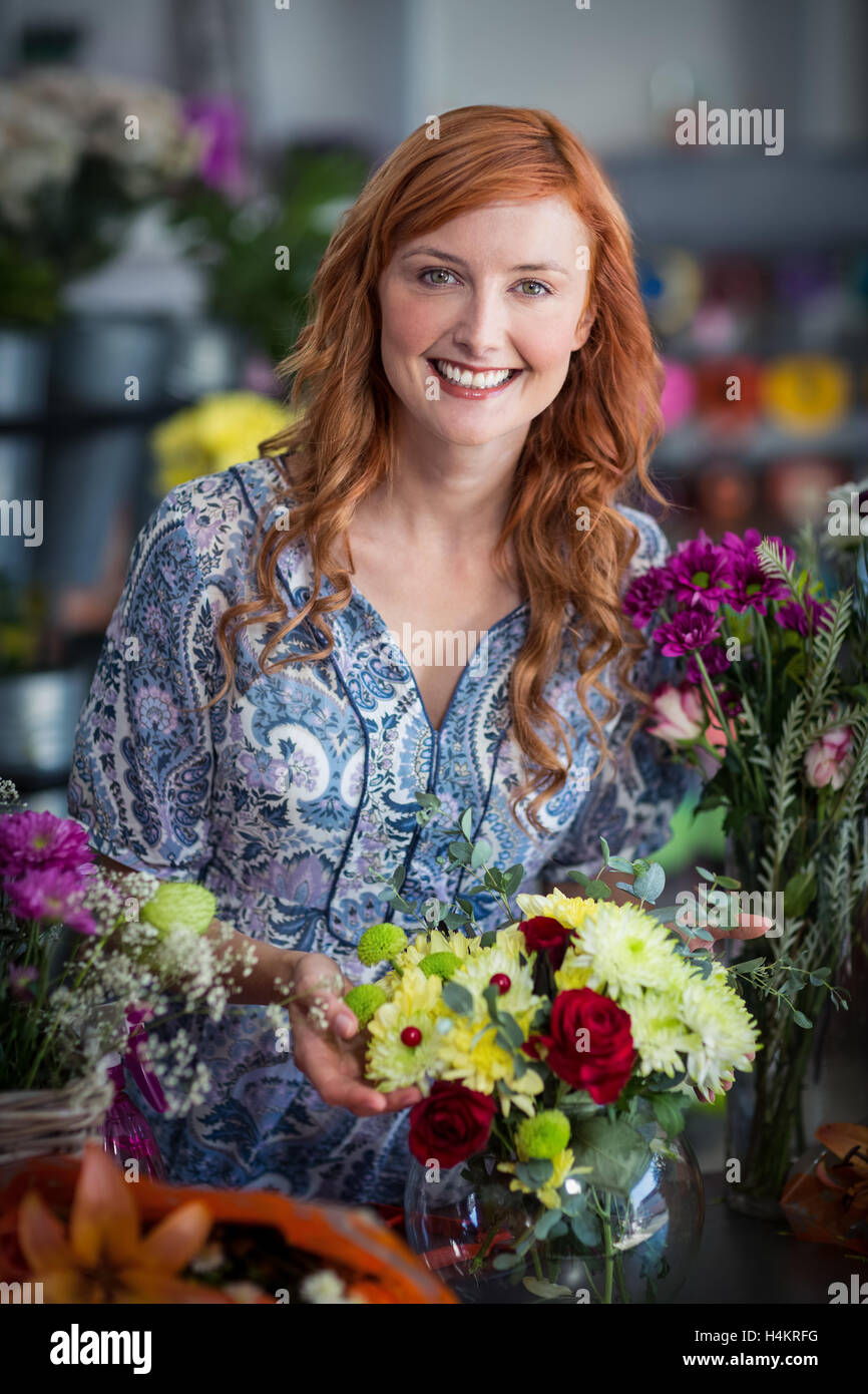 Fiorista femmina di controllo di una disposizione di fiori in vaso Foto Stock