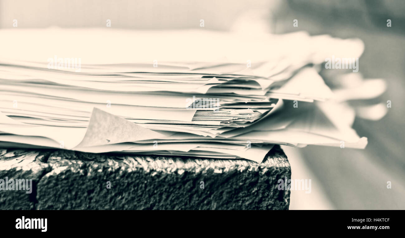 White pila di fogli di carta sulla scrivania di legno in bianco e nero Foto Stock