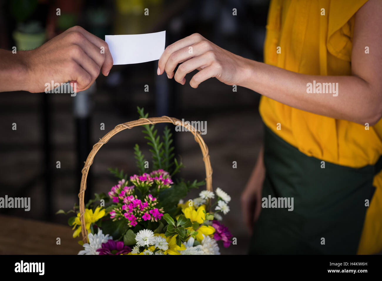 Fiorista femmina dando biglietto da visita al cliente Foto Stock