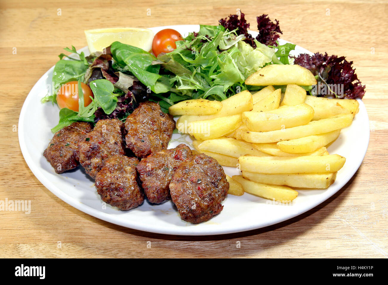 Grigliate di carne di manzo servita con le polpette con patate fritte e insalata mista Foto Stock