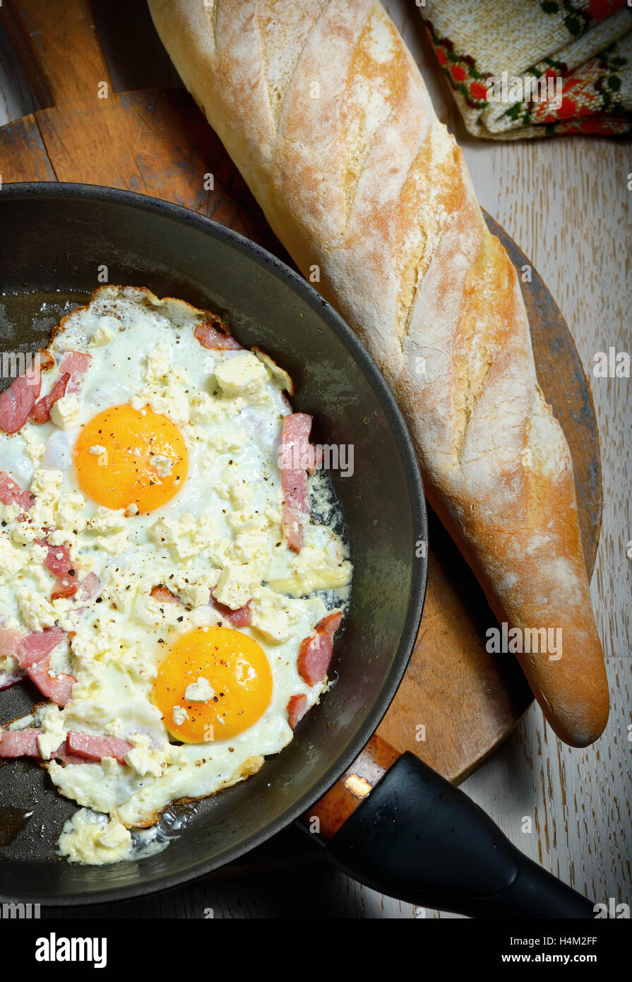 Uova fritte in padella con il pane per la colazione Foto Stock