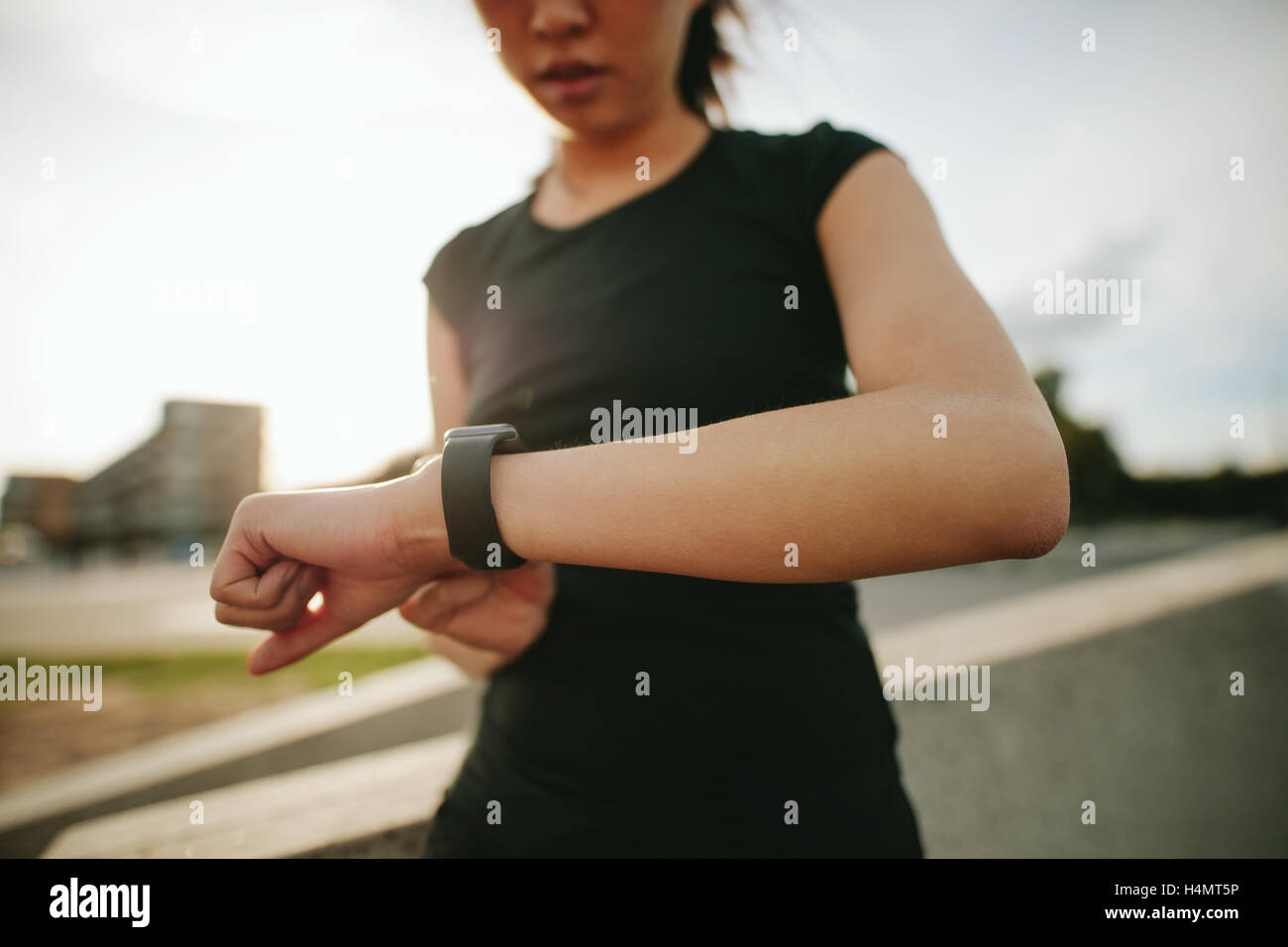 Immagine ravvicinata di giovane donna runner utilizzando smartwatch all'esterno. Femmina Fitness controllando la sua performance. Foto Stock