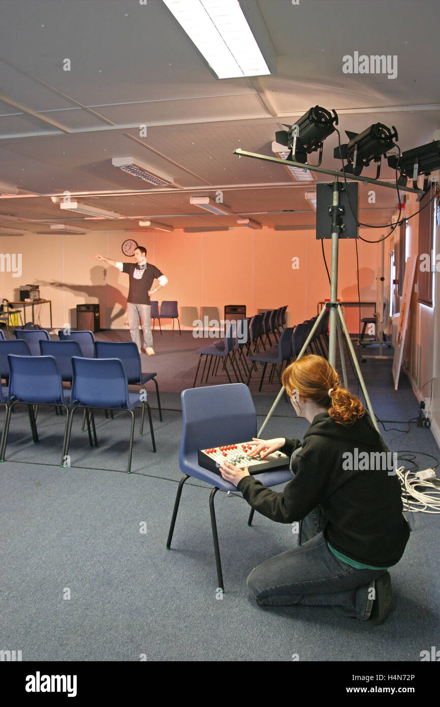 Uno studente opera di illuminazione teatrale nella scuola di dramma studio. Mostra dimmer e faretti Foto Stock